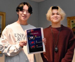 結果を手に笑顔の２人の写真